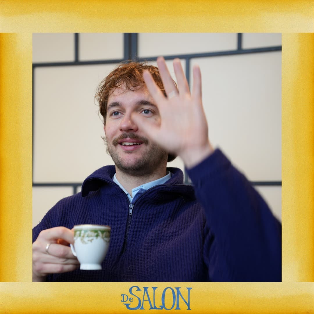De Salon-lid zwaait met een klein espressokopje